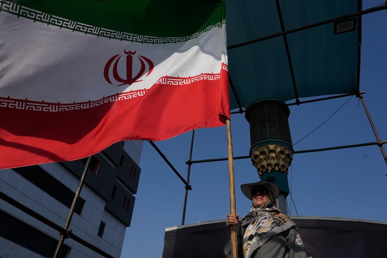 default-24 A woman holds an Iranian flag in Tehran.